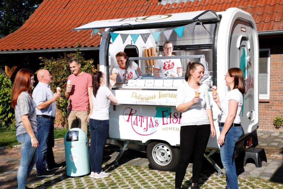 Kunden kaufen Eis an einem modernen Eiswagen mit Verkaufsklappe – Eiswagen kaufen für Events